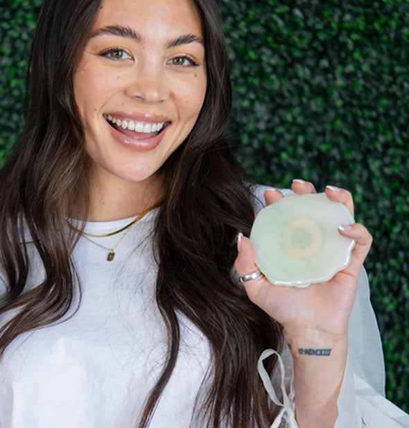 Smiling model holds a Crystal Quartz Wireless Charger in hand for size reference