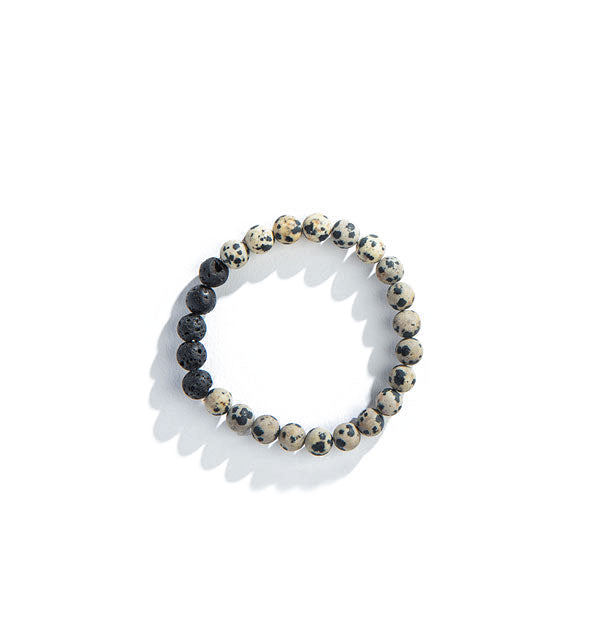 Spotted black and gray-brown jasper beads and black lava beads on a bracelet