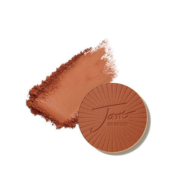 Round stamped Jane Bronzer compact refill with crushed product sample swatch behind, both in Dark shade