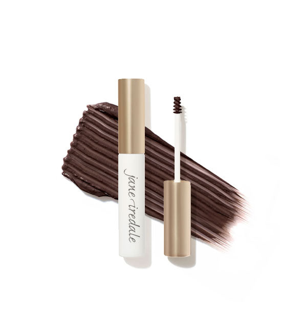 White and gold Jane Iredale brow gel tube with spoolie applicator shown features a product sample application behind in Dark Brown