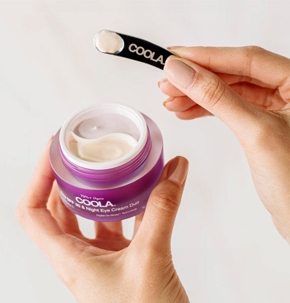 Model uses a small black Coola scooper with the Coola Day SPF 30 & Night Eye Cream Duo
