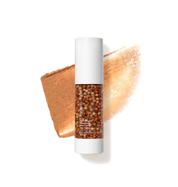 Bottle of Jane Iredale HydroPure Tinted Serum with color capsules visible through clear packaging and a sample application behind in the shade Deep 7