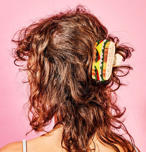 Model wears a hair clip designed to resemble a sandwich with lettuce, meat, cheese, and tomato on rye bread