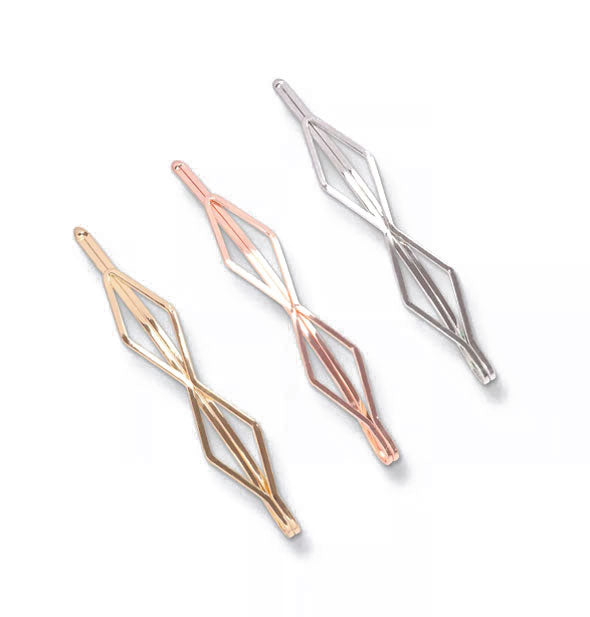 Three diamond-shaped bobby pins, one gold, one rose gold, and one silver