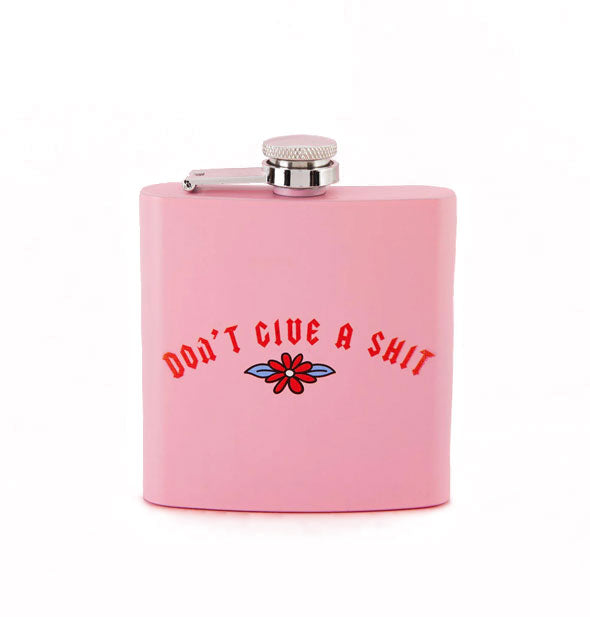 Square pink flask says, "Don't Give a Shit" in red lettering above a flower illustration