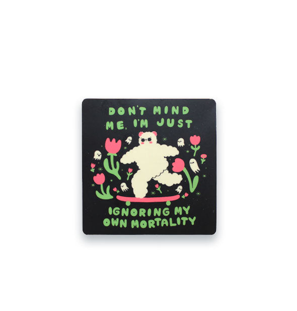 Square black sticker with rounded corners features illustration of a fluffy white bear surrounded by flowers and tiny ghosts with the words, "Don't mind me, I'm just ignoring my own mortality" in green bubble lettering