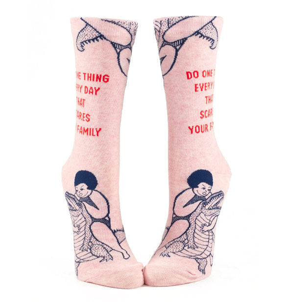 Light pink socks feature illustration of a girl wrestling an alligator in black and the words, "Do one thing every day that scares your family" in red