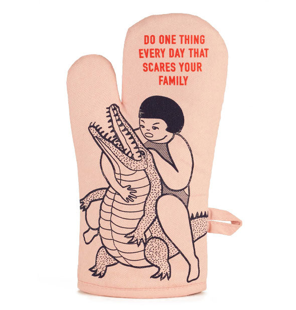 Light peachy-pink oven mitt features illustration of a girl wrestling an alligator in black and the words, "Do one thing every day that scares your family" in red above them