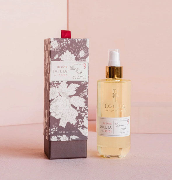 Glass bottle of Lollia Classic Petal In Love Dry Body Oil with decorative gray and white floral box