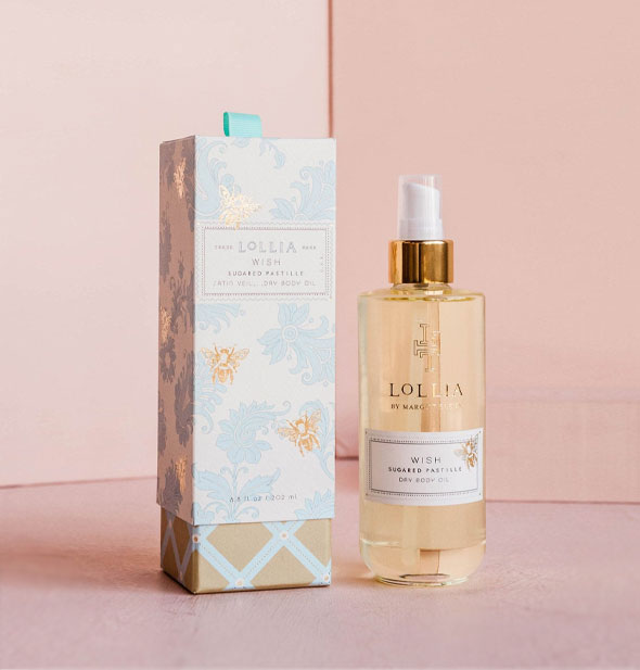 Glass bottle of Lollia Wish Sugared Pastille Dry Body Oil with blue and gold floral and plaid box with bee accents