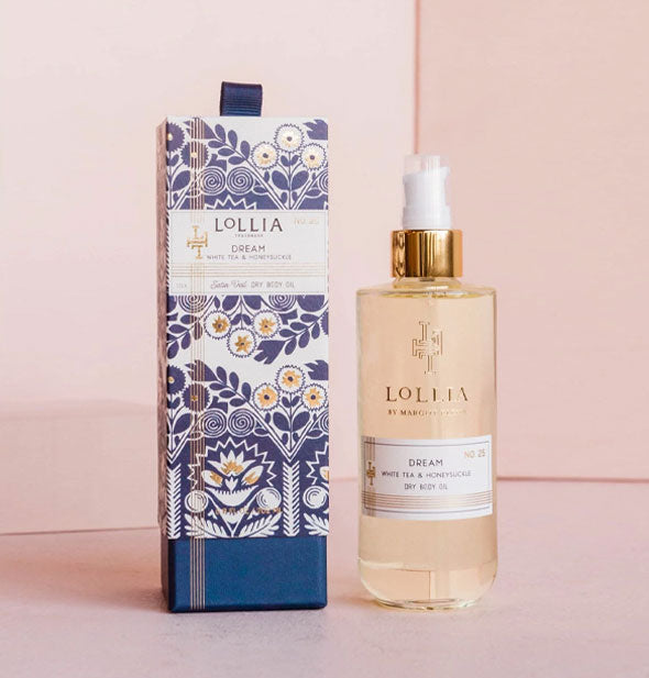 Clear glass bottle of Lollia Dream White tea & Honeysuckle Dry Body Oil next to decorative blue, white, and gold box