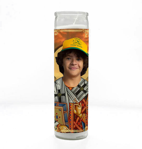 Tall white prayer candle in clear glass with all-over artwork depicting the character Eddie from Stranger Things as a saint