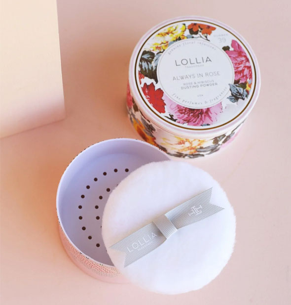 Opened Lollia Always In Rose Dusting Powder container reveals enclosed puff with ribbon handle