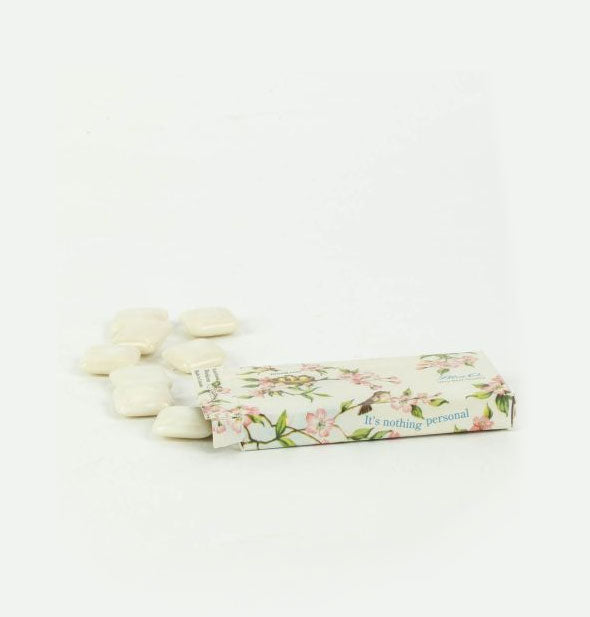 Pack of gum with floral design lays on its side and spills out contents