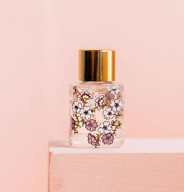 Detail of the back of a Lollia Little Luxe fragrance bottle featuring intricate floral designs