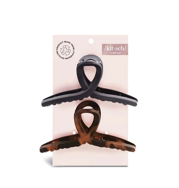 Two loop shape recycled material claw clips, one black and one brown tortoise, on light pink Kitsch blister card