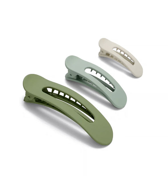 Three open-shape matte green and neutral hair clips with teeth