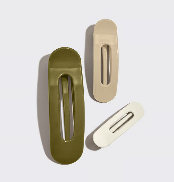 One large green hair clip, one medium-sized tan hair clip, and one small white hair clip, all with an elongated oval shape