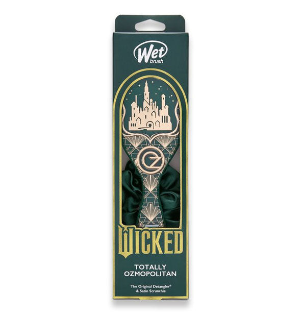 Wicked edition Wet Brush in Totally Ozmopolitan design features a green and gold art deco-style brush paddle and green scrunchie partially visible through window in packaging