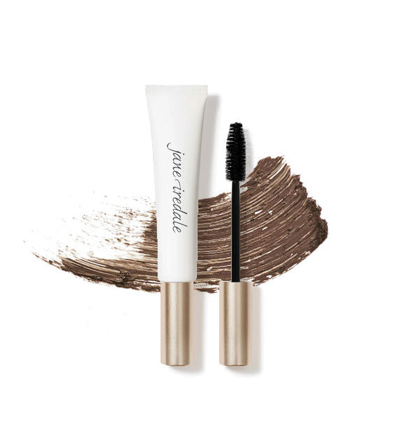 White and gold tube of Jane Iredale Longest Lash Mascara with separate applicator brush and a streak of product behind both in the shade Espresso