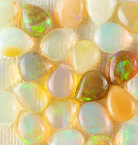An assortment of teardrop-shaped Ethiopian opals in a variety of colors with natural iridescence