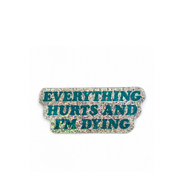 Sticker with holographic glitter finish says, "Everything hurts and I'm dying" in dark teal italic lettering