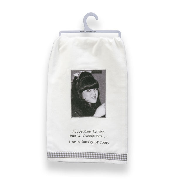 White dish towel on small gray hanger features a black and white retro photograph of a woman above the caption, "According to the mac & cheese box...I am a family of four."