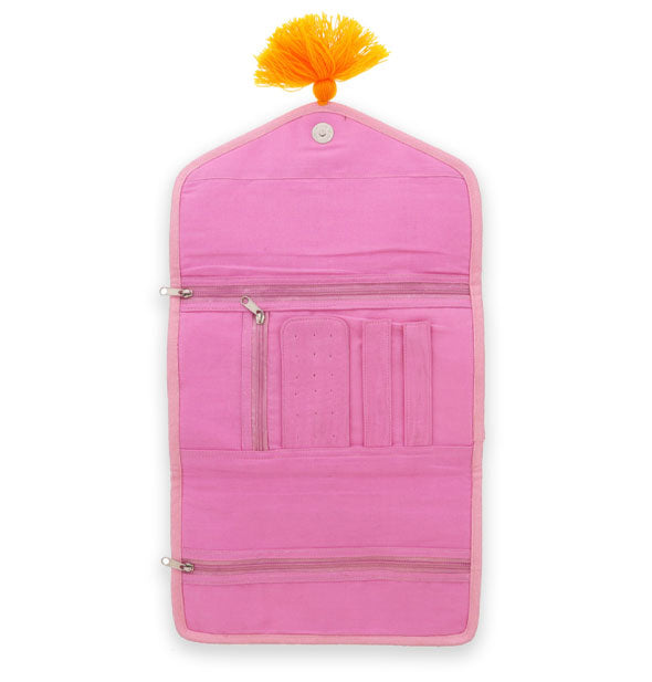 Unfolded pink jewelry organizer interior with pockets, zippers, top snap, and orange pompom pull