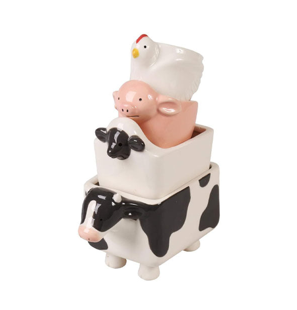 Upright stacked set of cow, sheep, pig, and chicken measuring cups