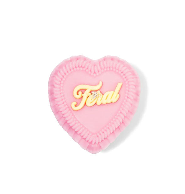 Pink heart-shaped candle designed as an elaborately iced cake that says, "Feral" in yellow script on top