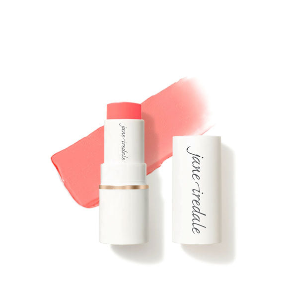 White tube of Jane Iredale Glow Time Blush Stick with cap removed and sample product application behind in matte shade Fervor