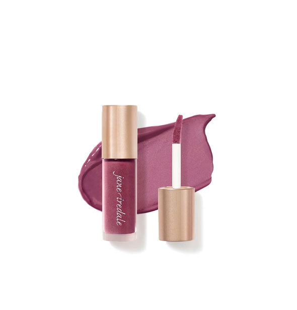 Tube of Jane Iredale Beyond Matte Lip Stain with separate gold doe foot applicator cap rest atop an enlarged sample application of product in shade Fetish