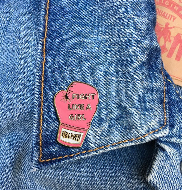 Fight Like a Girl boxing glove enamel pin on jean jacket lapel