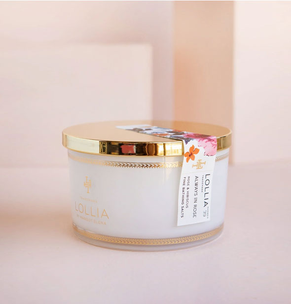 Tub of Lollia Always In Rose Fine Bathing Salts with shiny gold lid secured by a floral sticker label