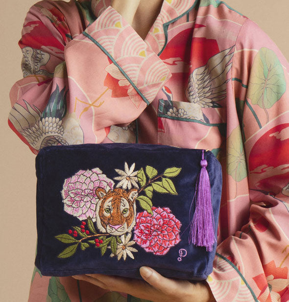 Model holds a dark blu Luxury Velvet Wash Bag with tiger and floral design
