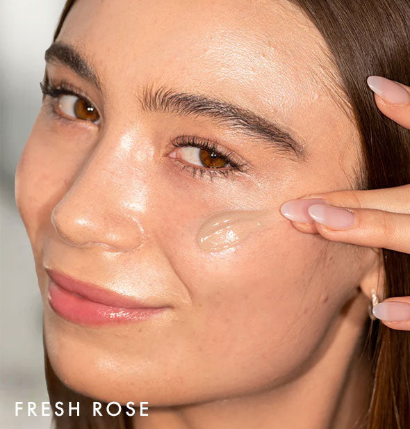 Model applies Coola Rosilliance Tinted Moisturizer Sunscreen in shade Fresh Rose to cheek