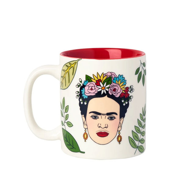 White coffee mug with red interior features illustration of Frida Kahlo wearing a colorful flower crown and surrounded by green foliage