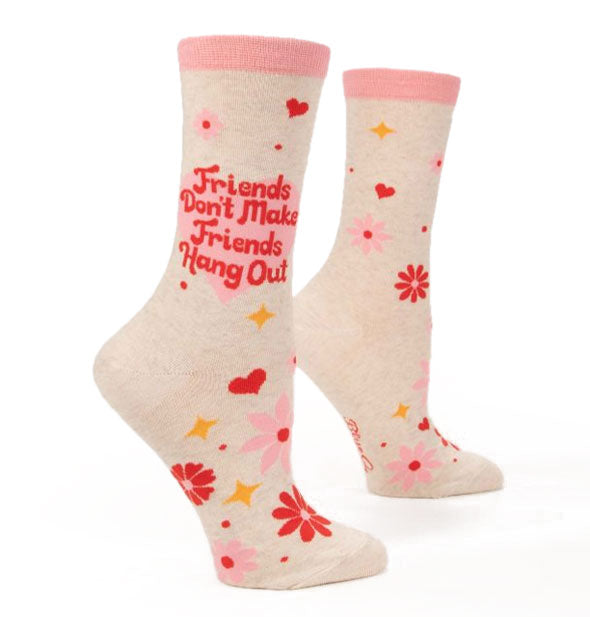 Pair of white socks with light pink top band and all-over pink and red flowers, red hearts, and yellow stars say, "Friends don't make friends hang out" in red lettering over a light pink heart on the outside ankle