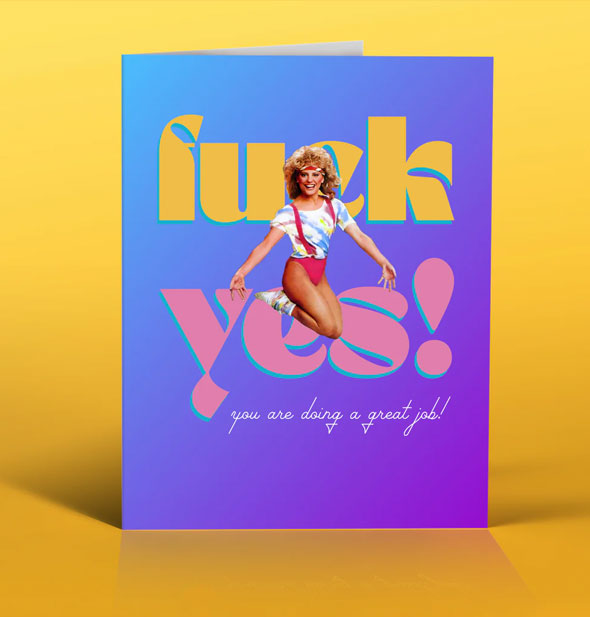 Purple greeting card on yellow background features image of a woman jumping in the air in front of the words, "Fuck yes!" in large yellow and pink lettering; below is the caption, "You are doing a great job!" in small white script