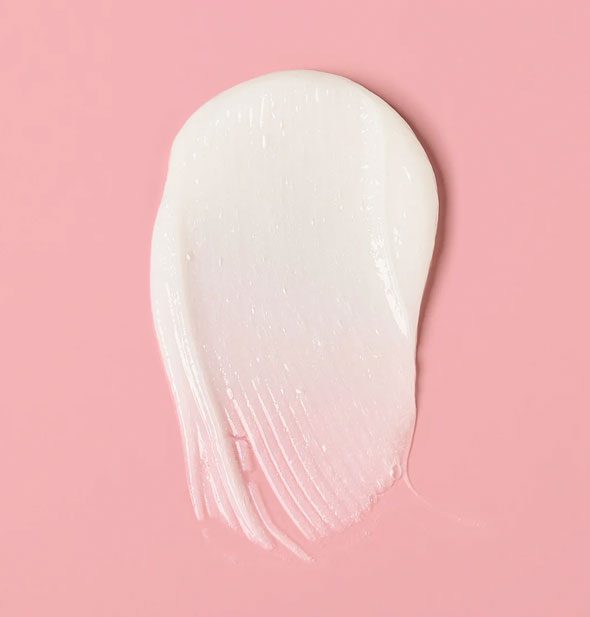 Closeup of a daub of white, creamy Verb Ghost Conditioner on a pink surface