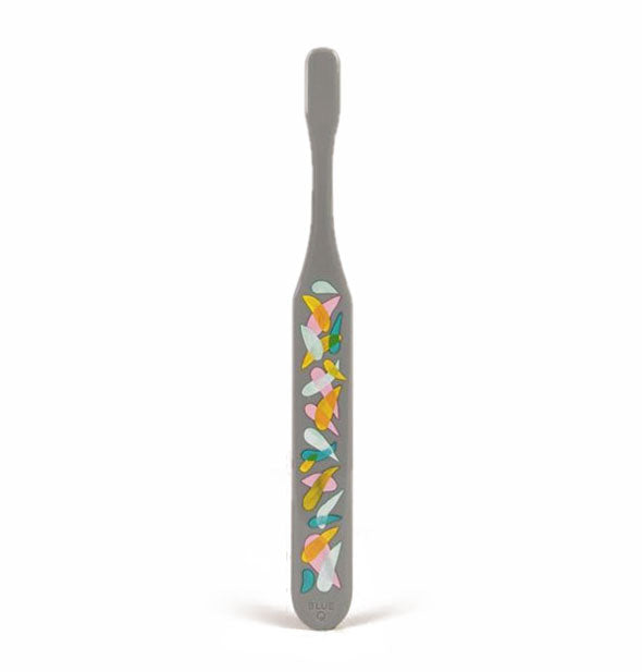 Reverse side of gray toothbrush with multicolor swishes