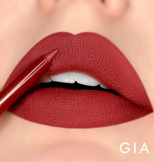 Model's lips wear shade Gia of Kara Beauty Line Up Lip Liner; pencil tip is held up to upper lip