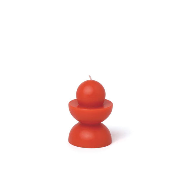 Small, red-orange candle features two half-circle shapes with a sphere on top
