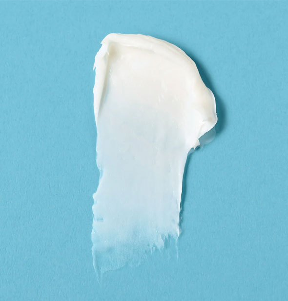 Closeup of a daub of white, creamy Verb Glossy Conditioner on a blue surface