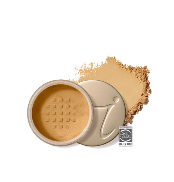 Opened round Jane Iredale loose powder compact with stamped gold lid and product application behind it in shade Golden Glow