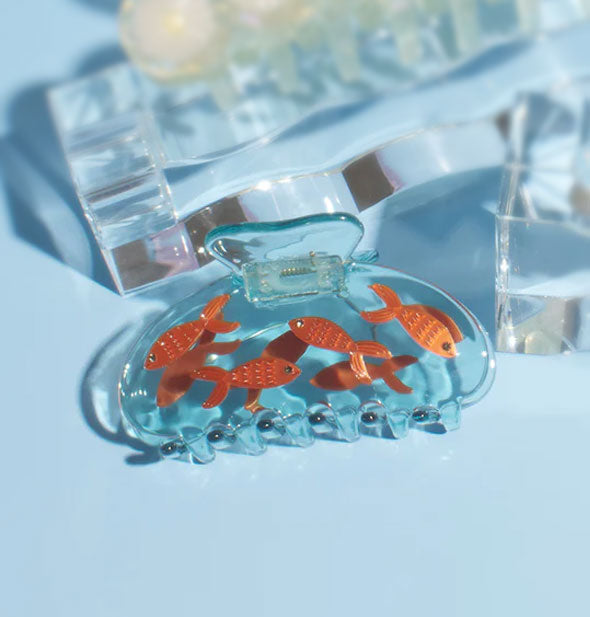 Clear blue claw clip features embedded goldfish details