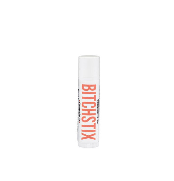 White tube of Bitchstix lip balm with red-orange lettering