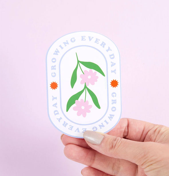 Model's hand holds a Growing Everyday flowers sticker
