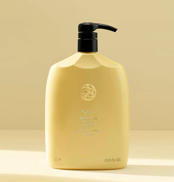 Pale yellow 33.8 ounce bottle of Oribe Hair Alchemy Resilience Conditioner with gold lettering and black pump nozzle