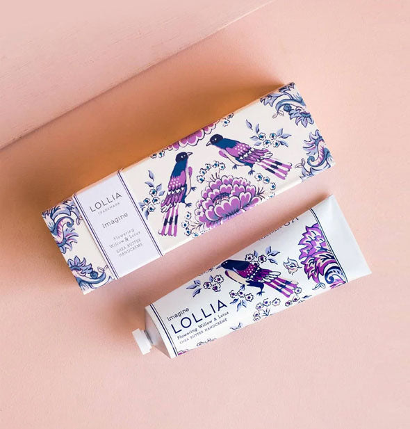 White tube and box of Lollia Imagine Handcreme with blue and purple floral and birds design on each